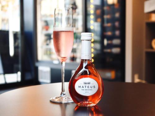 a bottle of wine next to a glass of wine at GEMS YUFUIN Hotel and Spa Cafe Bar in Yufuin
