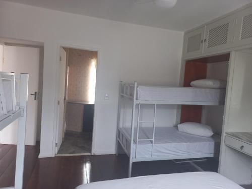 a room with two bunk beds and a hallway at Pousada Rota do Sol in Cabo Frio