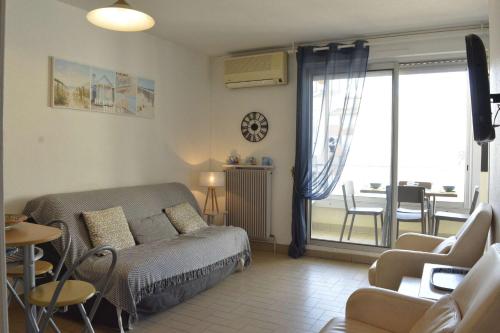 Cet appartement comprend une chambre avec un lit et un salon avec un balcon. dans l'établissement Appt 2 pièces cabine 6 couchages CAP D'AGDE CT100-010, au Cap d'Agde