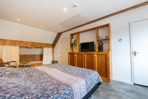 a bedroom with a bed and a flat screen tv at Appartementen De Witte Brugh in Buren