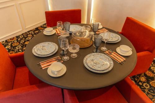 a table with plates and glasses on it in a restaurant at The Zoey Villa, with Central Heating, Bonfire, BBQ & Complimentary Breakfast in Gulmarg