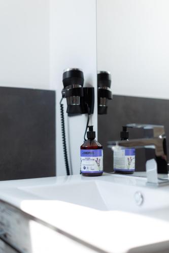 una bottiglia di medicinale appoggiata su un ripiano in un bagno di Adventure Lake Resort - Simared a Baia Mare
