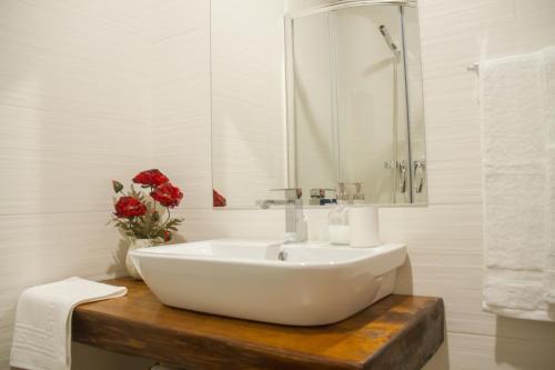 a white bathroom with a sink and a mirror at Refúgios do Pinhal in Oleiros