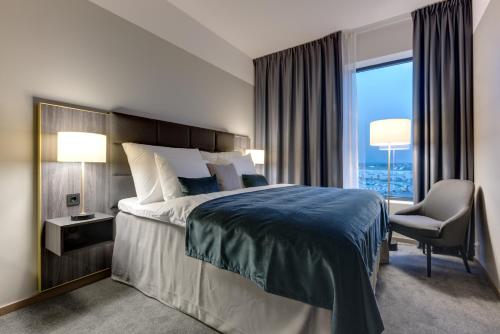 ソラにあるClarion Hotel Airのベッド1台、椅子、窓が備わる客室です。