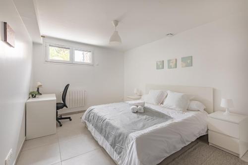 une chambre blanche avec un lit et un bureau dans l'établissement Maison calme à 20 minutes de Paris, à Vitry-sur-Seine