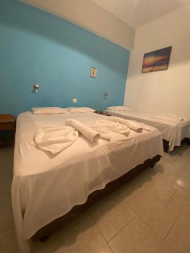 two beds in a room with white sheets at Orthi Ammos in Frangokastello