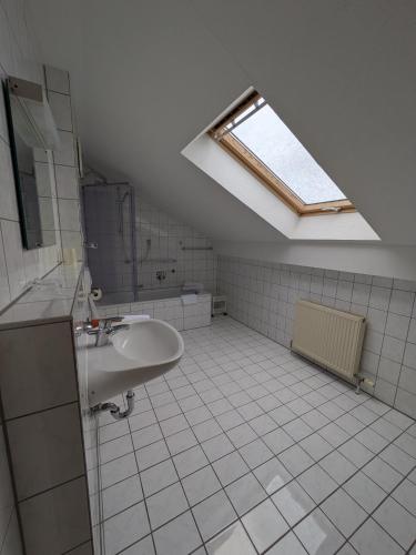 a bathroom with a sink and a skylight at Pension Dornröschen in Bad Füssing