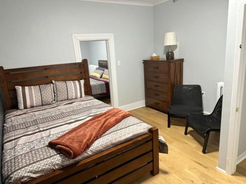 a bedroom with a bed and a chair and a mirror at Spacious Stylish Gem Steps from the Pier in Halifax