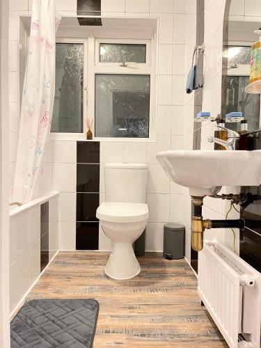 a bathroom with a toilet and a sink at Shepherds House - 3 bedroom in Goodmayes