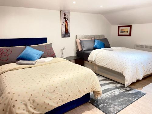 a bedroom with two beds and a couch at Shepherds House - 3 bedroom in Goodmayes