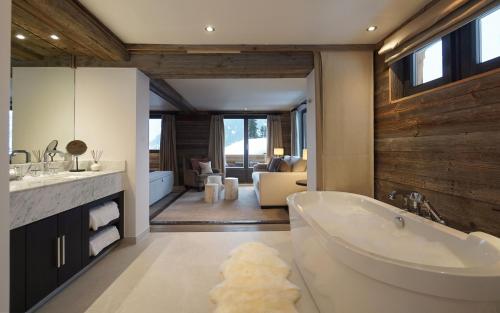 a bathroom with a large tub and a living room at The Lodge in Verbier