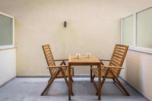 two chairs and a wooden table in a room at Soho Harbor by halu! in Thessaloniki