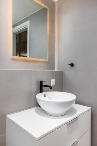 a bathroom with a white sink and a mirror at Soho Harbor by halu! in Thessaloniki