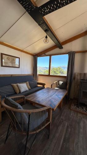 a living room with a couch and a table at Cuatro Vientos Patagonia - Lago Huechulafquen in Junín de los Andes