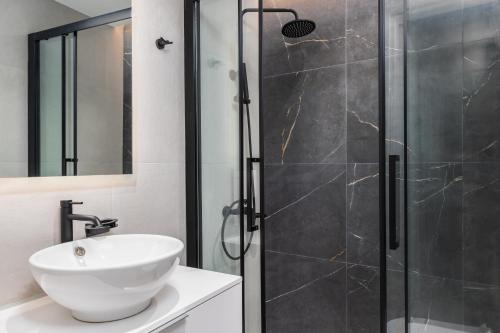 a bathroom with a shower with a sink and a toilet at Soho Harbor by halu! in Thessaloniki