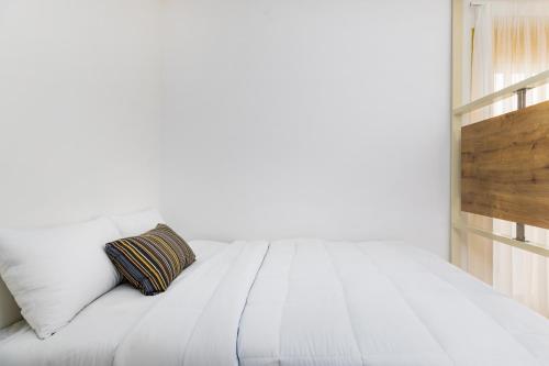 a white bed with a pillow on top of it at Soho Harbor by halu! in Thessaloniki