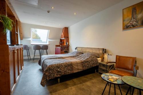 a bedroom with a bed and a table and chairs at Appartementen De Witte Brugh in Buren