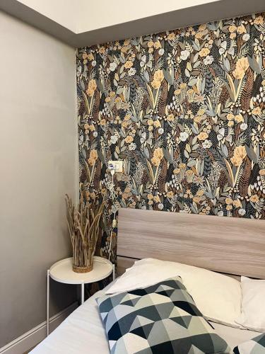 a bedroom with a bed with a floral wallpaper on the wall at "Marcello's Home" in Catania