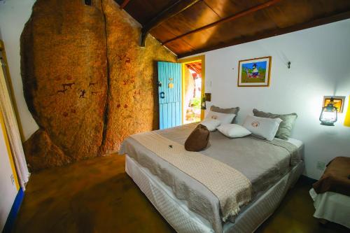 une chambre avec un grand lit dans une pièce dans l'établissement Pousada Colina dos Flamboyants, à Cerro-Corá