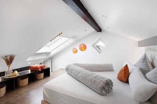a white bedroom with a bed and a couch at Ferienwohnung am Schönbach in Utting am Ammersee