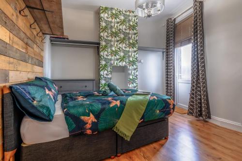 a bedroom with a bed in a room with wooden floors at Victorian High Street flat, parking, WiFi in Bristol