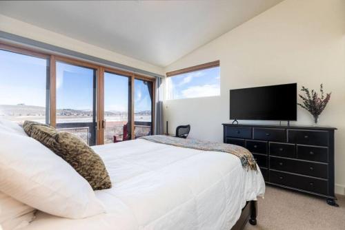 a bedroom with a large white bed with a television at Mountain Retreat Hot Tub Views,Near Shops in Park City