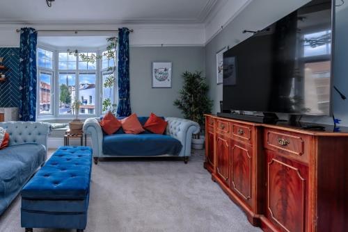 a living room with a large television and a couch at Victorian High Street flat, parking, WiFi in Bristol