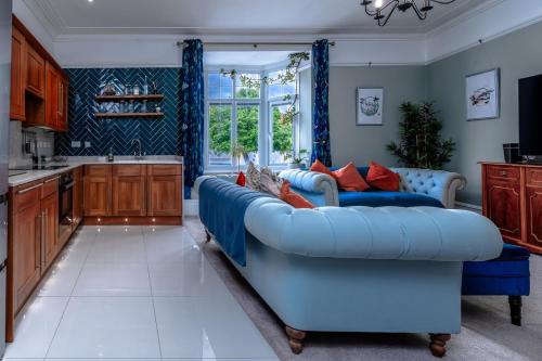a living room with a blue couch in a kitchen at Victorian High Street flat, parking, WiFi in Bristol