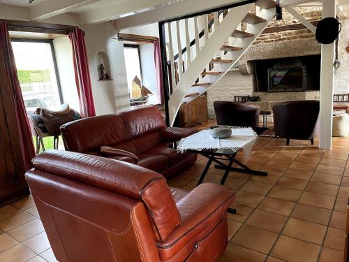 a living room with a leather couch and a table at Pont-Aven Breton house in Pont-Aven
