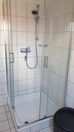 a shower with a glass door in a bathroom at Ferienhaus Marion in Neßmersiel