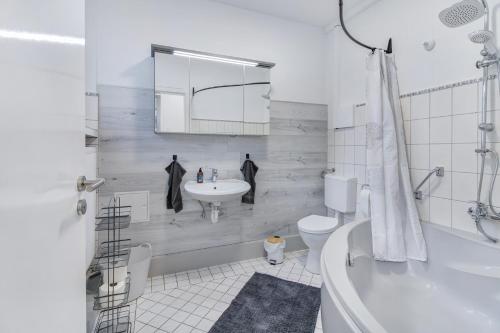 a bathroom with a sink and a toilet and a tub at 24-7 Living - Modern Apartments in Waltrop with Top Connection in Waltrop