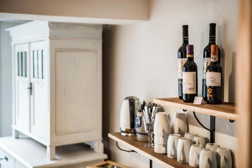 a kitchen with two shelves with bottles of wine at B3 Boutique-Bed&Breakfast in Gsteigwiler