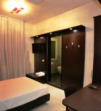 a bedroom with a bed and a table and a mirror at La Casa Degli Angeli - Agli Angeli Ristorante Pizzeria in Pertegada