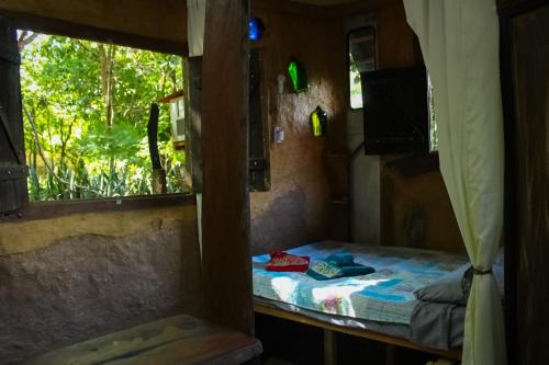 a small room with a bed and a window at A Casinha do Forneiro in Bonito