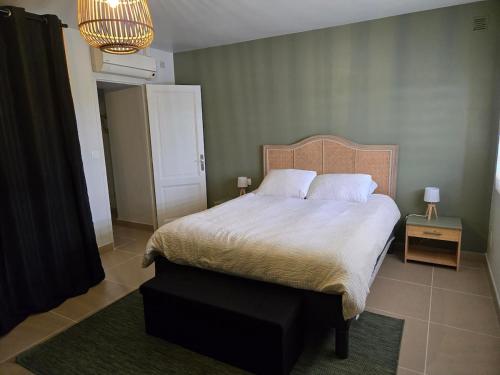 une chambre avec un lit et une table de chevet avec une lampe dans l'établissement Le Cottage des Vignes, à Saint-Christophe-des-Bardes