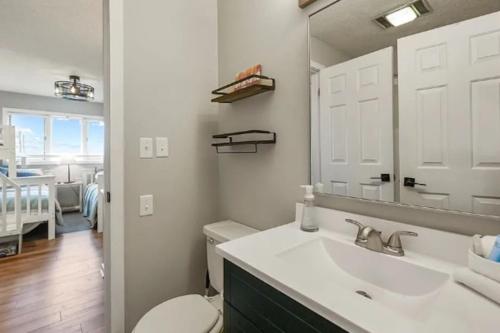 a bathroom with a sink and a toilet and a mirror at Ozark Lakeview Penthouse 3bed 3bath Condo in Osage Beach Escape in Osage Beach