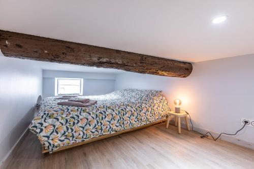- une chambre avec un lit et une poutre en bois dans l'établissement Casa feracci, à Villefranche-sur-Mer