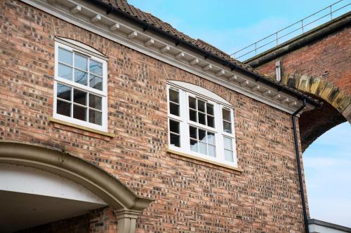 two windows on the side of a brick building at NEW! 2BR in Stephenson House in Stockton-on-Tees