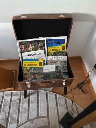 a suitcase full of magazines sitting on a table at La chambre d hôtes By Georges in Scharrachbergheim Irmstett