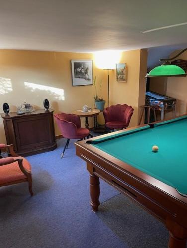 a living room with a pool table and chairs at La chambre d hôtes By Georges in Scharrachbergheim Irmstett