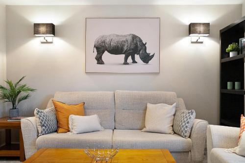 a living room with a couch and a picture of a rhino at NEW! 2BR in Stephenson House in Stockton-on-Tees