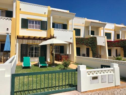 a house with two chairs and an umbrella at Seaview Benagil Villa 15 in Benagil