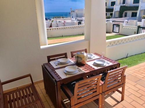 a wooden table with two chairs and a table with a table at Seaview Benagil Villa 15 in Benagil