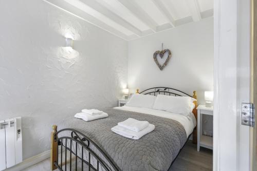 a bedroom with a bed with two towels on it at Minnows Rest - North East Escapes in Seahouses