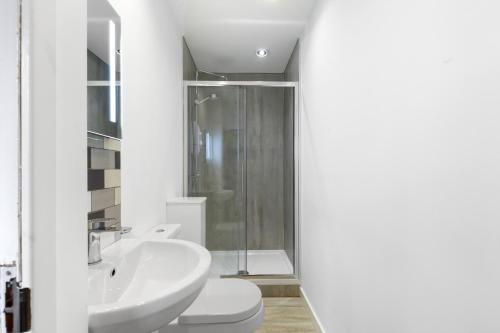 a bathroom with a sink and a toilet and a shower at Minnows Rest - North East Escapes in Seahouses