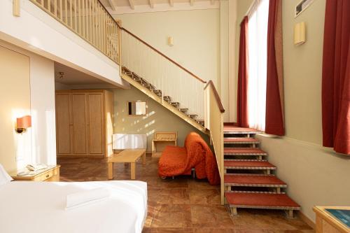 a room with a staircase and a bed and a bedroom at Hotel Belvedere San Gottardo by LVG Hotel Collection in Verbania