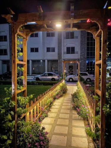 a garden walkway with a wooden arch in front of a building at Elite apartment private beach Holiday Chalet Free WIFI in Hurghada