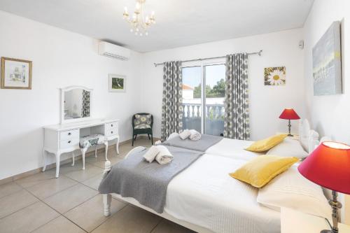 a bedroom with a bed and a desk and a window at Casa Sentosa in Carvoeiro