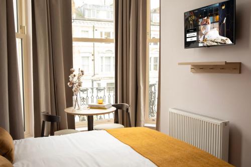 a bedroom with a bed and a table and a window at Bob W London Holland Park in London