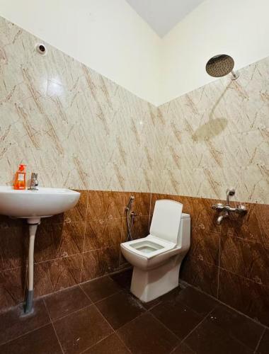 a bathroom with a toilet and a sink at Deluxe Rooms near Tree Park Metro station Whitefield in Bengaluru